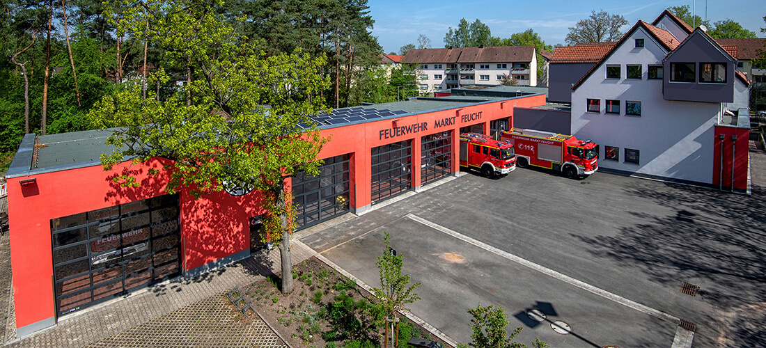 Fischer Planen und Bauen - Freiwillige Feuerwehr Feucht aussen mit zwei Feuerwehrfahrzeugen