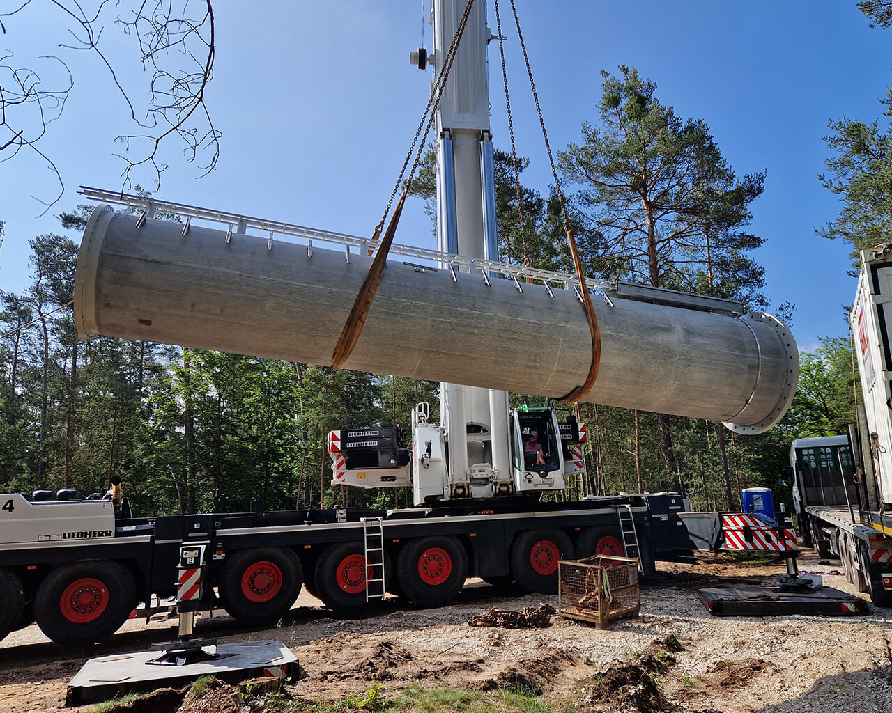 Baumaßnhamen für einen Mobilfunkmasten – Kran hebt Mastelement